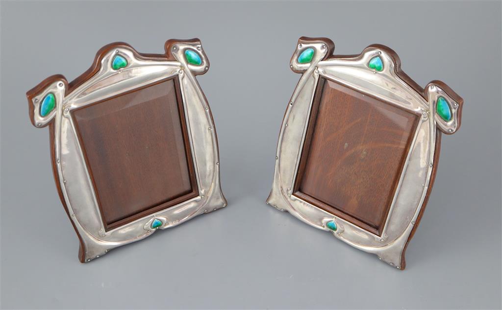 A matched pair of Edwardian Art Nouveau silver and enamel photograph frames,